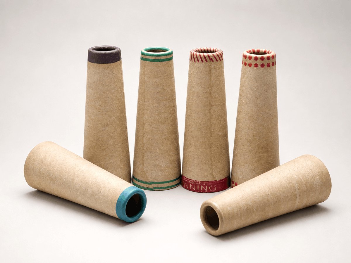 Six kraft paper yarn cones and tubes with assorted colored rim finishes — purple, green, red striped, red dotted, teal and plain